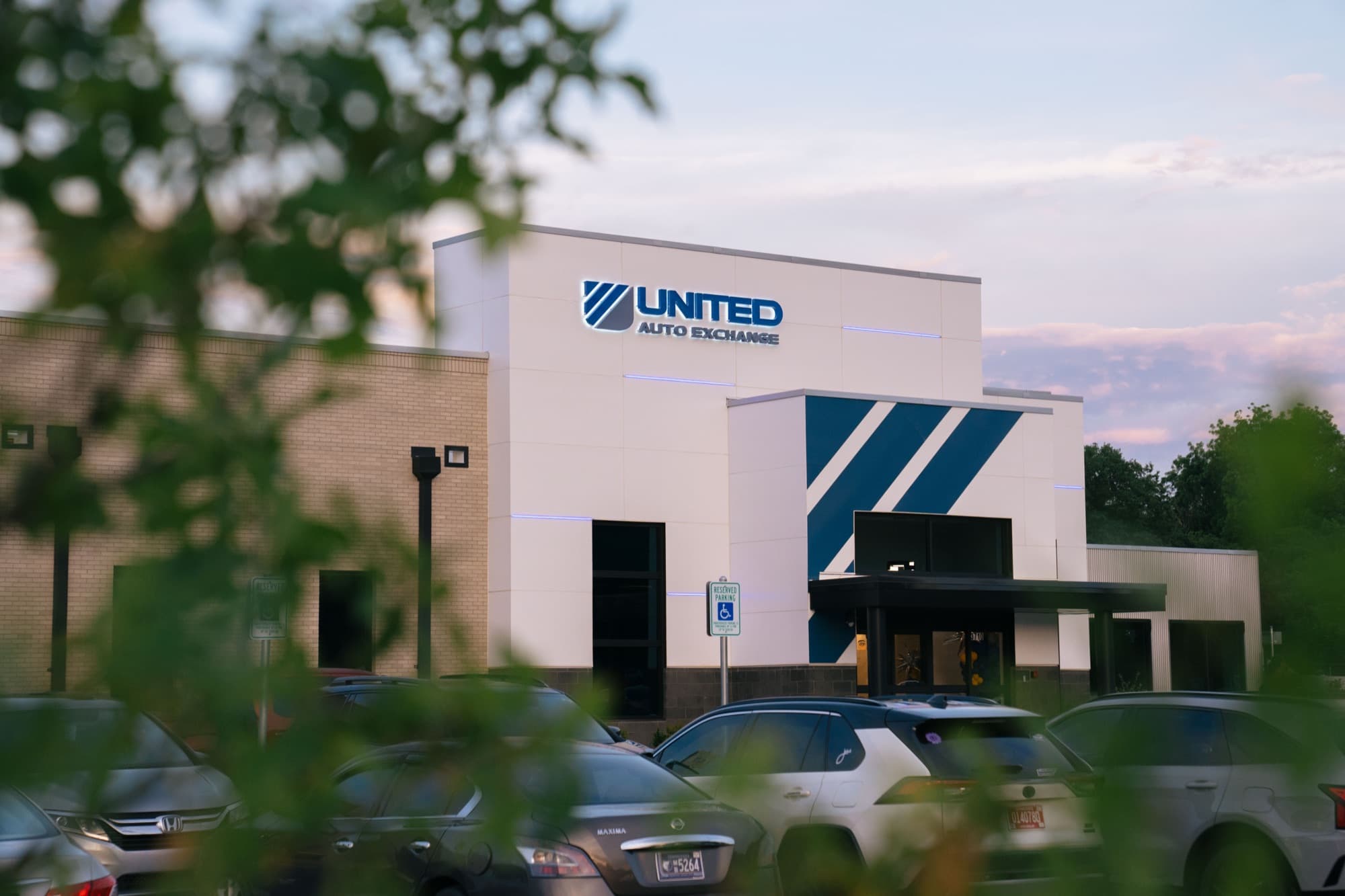 United Auto Exchange exterior at dusk, signage visible against the evening sky.